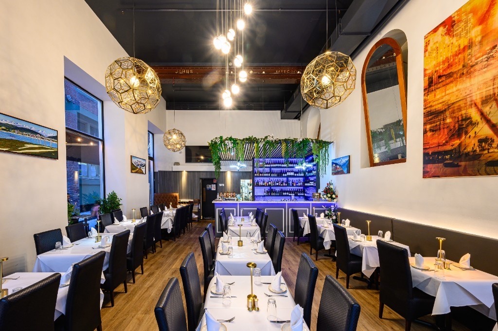 Aagaman restaurant dining room — white tablecloths, warm lighting and full bar